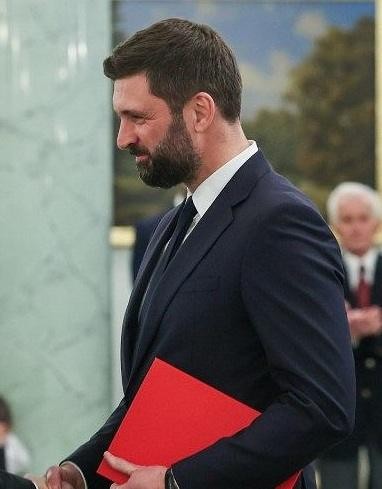 Nikodem Rachoń w kontekście swojej kariery zawodowej, symbolizujący jego przejście z sektora prywatnego do dyplomacji.