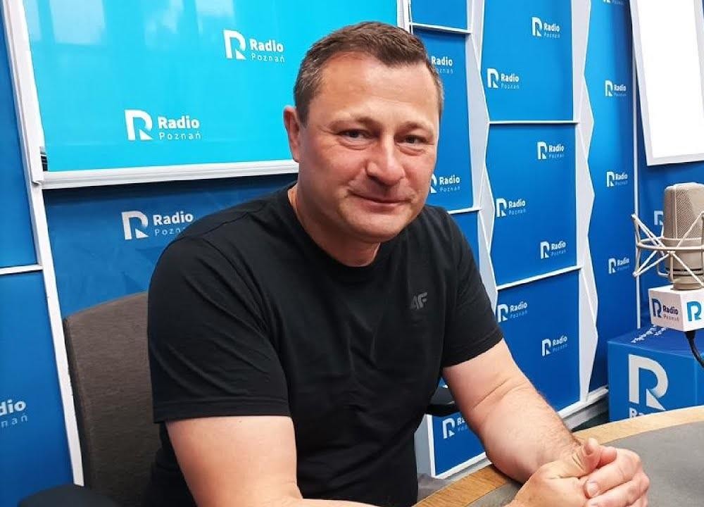 Krzysztof Paszyk przemawiający podczas konferencji prasowej lub posiedzenia parlamentu, w tle widoczne symbole państwowe.