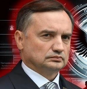 Zbigniew Ziobro siedzący przed komisją śledczą w parlamencie, otoczony mikrofonami i dokumentami, z napiętą atmosferą.