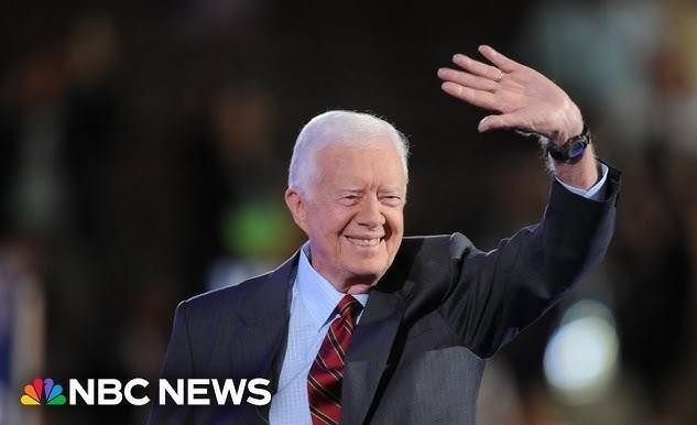 Jimmy Carter prowadzący działalność humanitarną, być może budujący dom z Habitat for Humanity, ukazujący jego aktywną rolę po prezydenturze.
