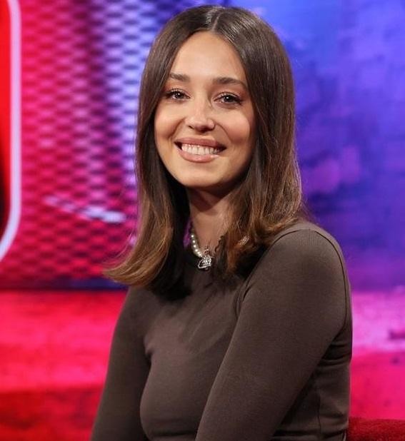 Izabella Krzan w profesjonalnym studiu telewizyjnym, dynamicznie prowadząca program, ukazująca zaangażowanie i energię.