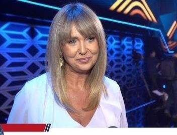 Ewa Wachowicz w kuchni, gotująca z pasją, otoczona świeżymi składnikami.