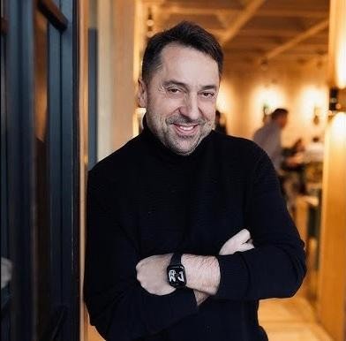 Marcin Miller, lider zespołu Boys, uśmiechnięty, w interakcji z fanami podczas koncertu lub spotkania, z widownią w tle.