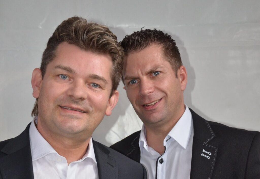 Ryszard Warot, lider zespołu Akcent, podczas energicznego występu na scenie, w otoczeniu dynamicznego oświetlenia i publiczności.