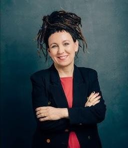 Olga Tokarczuk podczas publicznego wystąpienia lub odbierania nagrody, z wyrazem skupienia i inspiracji.