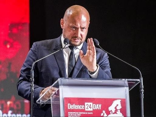 Jacek Siewiera w trakcie misji medycznej, w stroju medycznym, w dynamicznej scenie symbolizującej jego zaangażowanie i profesjonalizm w działaniach ratunkowych.